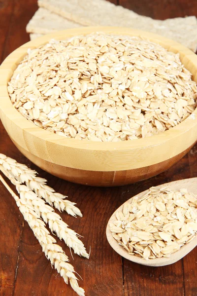 Oat flakes in wooden bowl on the table — Stock Photo, Image