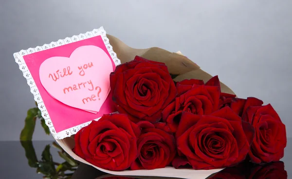 Hermoso ramo de rosas rojas con San Valentín sobre fondo gris — Foto de Stock