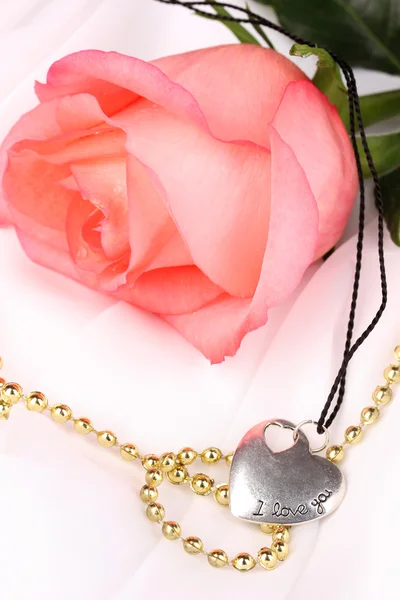 Tender pink rose with heart pendant — Stock Photo, Image