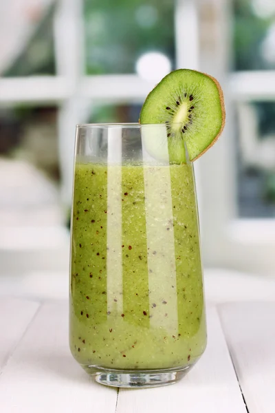 Glass of fresh kiwi juice on wooden table, on window background — Stock Photo, Image