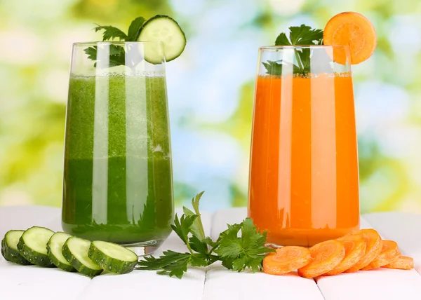 Fresh vegetable juices on wooden table, on green background — Stock Photo, Image