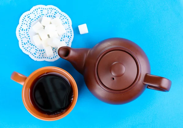 Draufsicht auf Tasse Tee und Teekanne auf blauen Tischdecken — Stockfoto