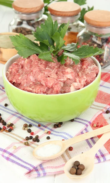 Bowl of raw ground meat with spices on wooden table — Stock Photo, Image