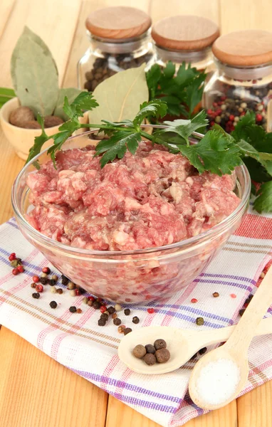 Bowl of raw ground meat with spices on wooden table — Stock Photo, Image
