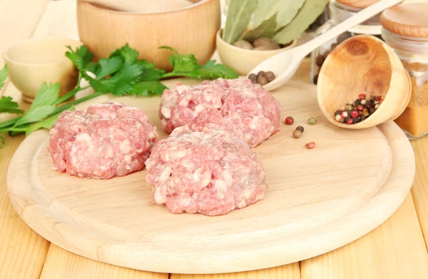RAW köttbullar med kryddor på träbord — Stockfoto