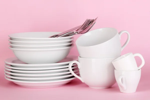 Чистые белые блюда на розовом фоне — стоковое фото