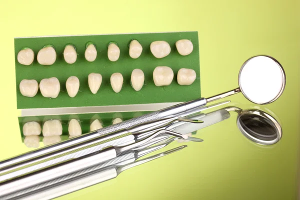 Conjunto de ferramentas dentárias com dentadura em fundo verde — Fotografia de Stock