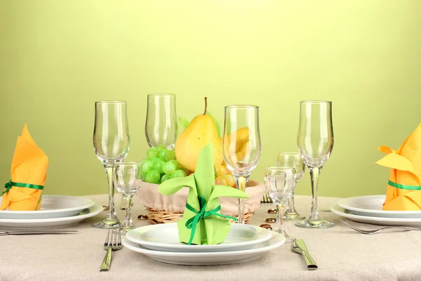 Table setting in green and yellow tones on color background — Stock Photo, Image