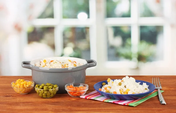 Risotto in grijze pot op houten tafel op lichte achtergrond — Stockfoto