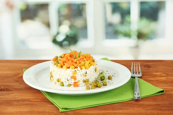 Risotto on plate on wooden table on bright background — Stock Photo, Image