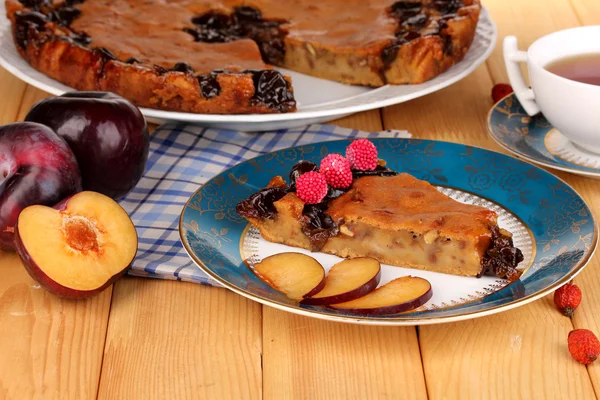 Sabroso pastel en plato sobre mesa de madera — Foto de Stock