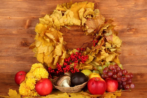 Herbstliche Komposition mit gelben Blättern, Äpfeln und Pilzen auf hölzernem Hintergrund — Stockfoto