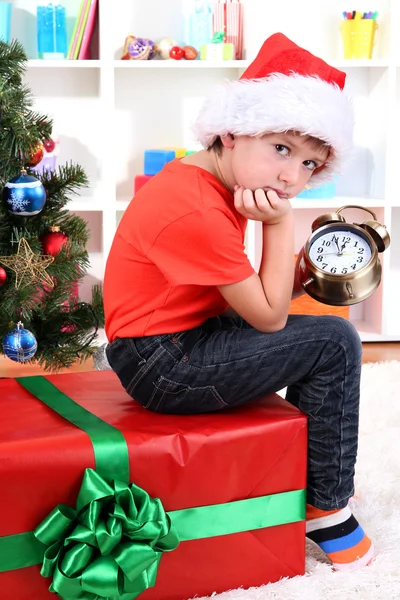 Little boy with big gift and clock in anticipation of New Year Royalty Free Stock Images