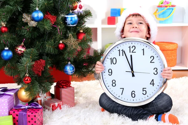 Little boy with clock in anticipation of New Year Stock Picture