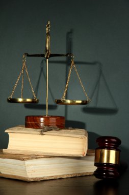 Altın pul, adalet, tokmak ve gri arka plan üzerine kitaplar