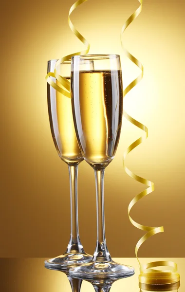 香槟和流光在黄色背景上的眼镜 — 图库照片