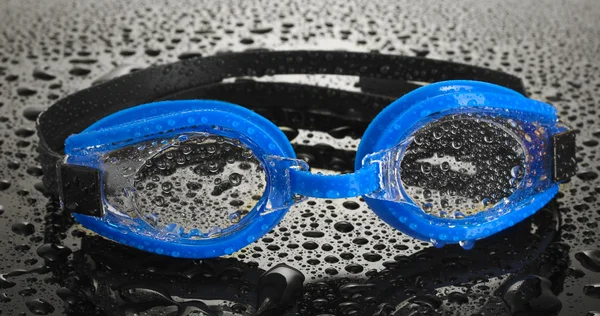 Blue swim goggles with drops on grey background — Stock Photo, Image