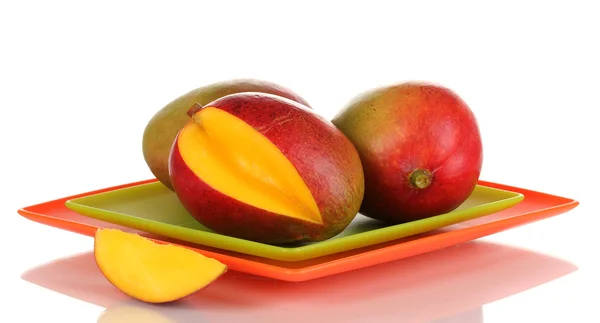 Reife appetitliche Mango auf rotem Teller isoliert auf weißem — Stockfoto