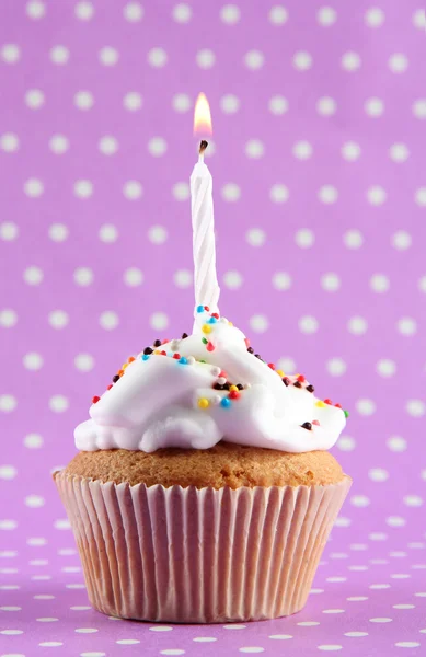 Tasty birthday cupcake with candle, on purple background — Stock Photo, Image