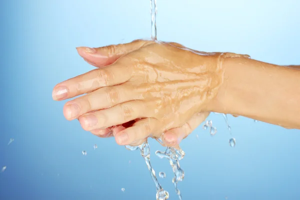 Lavarsi le mani su sfondo blu primo piano — Foto Stock