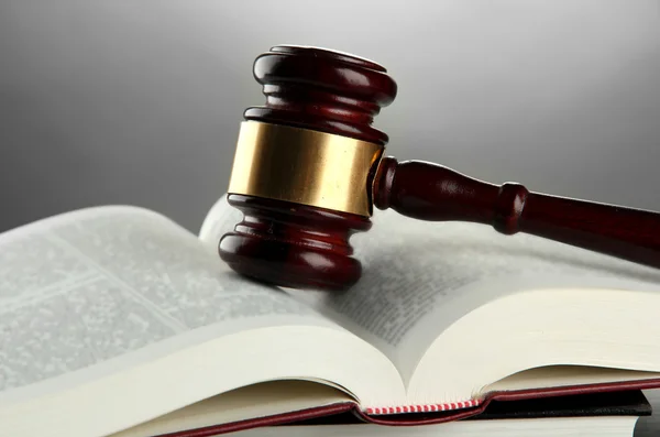 Wooden gavel and books, on grey background — Stock Photo, Image