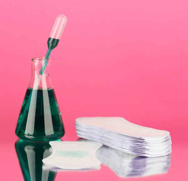 Testing sanitary pads for absorbency, on blue background closeup Stock