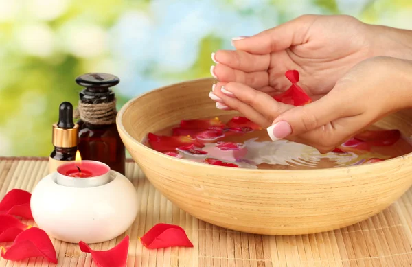 Tratamentos de spa para mãos femininas, em fundo verde — Fotografia de Stock