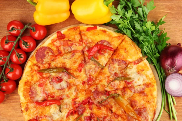 Ízletes pepperoni pizza zöldségekkel, fából készült táblán a fából készült háttér — Stock Fotó