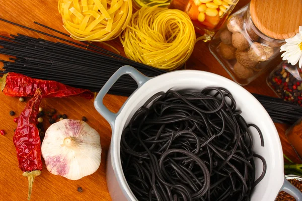 Pasta spagetti, grönsaker och kryddor på träbord på trä bakgrund — Stockfoto