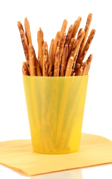 Palitos crocantes saborosos em copo de plástico amarelo isolado no branco — Fotografia de Stock