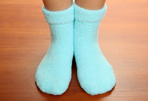 Pernas femininas em meias azuis no chão laminado — Fotografia de Stock
