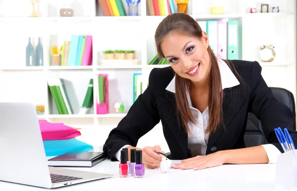 Geschäftsfrau lackiert Nägel am Arbeitsplatz — Stockfoto