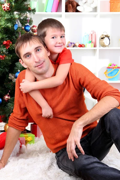 Vader en zoon in de buurt van de kerstboom — Stockfoto