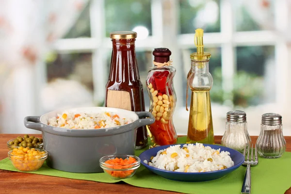 Risotto en pot gris sur table en bois sur fond lumineux — Photo