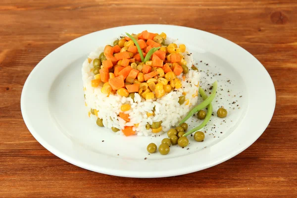 Risotto on plate on wooden background — Stock Photo, Image