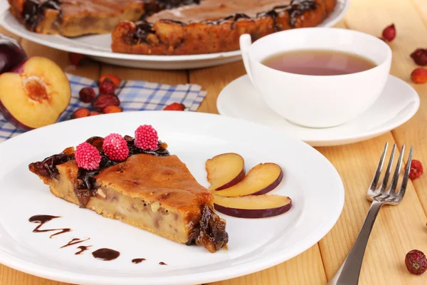 Tasty pie on plate on wooden table — Stock Photo, Image