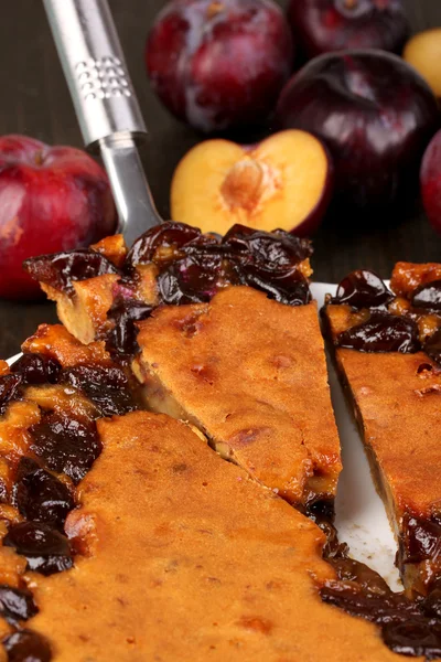 木製のテーブルに梅とプレートにおいしいパイ — ストック写真