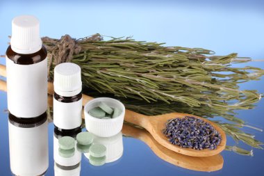 mavi arka plan üzerinde otlar ve ilaç şişeleri. homeopati kavramı