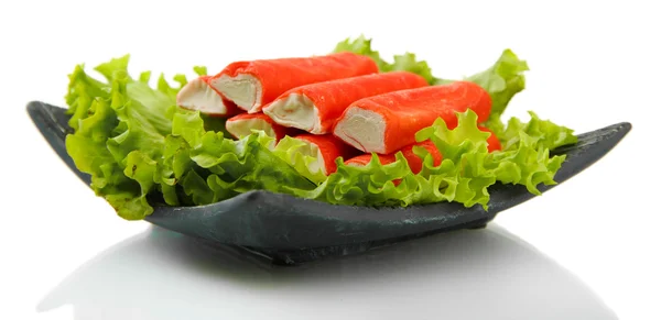 Palitos de cangrejo con hojas de lechuga y limón en plato aislado en blanco — Foto de Stock