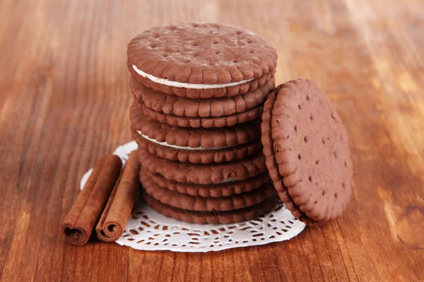 Čokoládové cookies s krémovou vrstvu na dřevěný stůl detail — Stock fotografie
