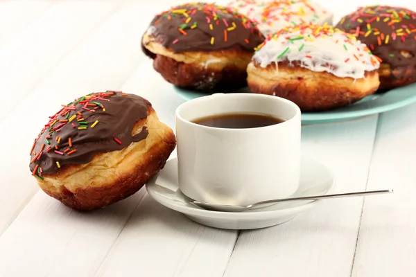 Leckere Donuts auf Farbteller auf hellem Holzhintergrund — Stockfoto