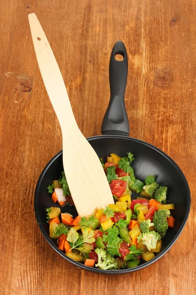 Нарезанные свежие овощи в кастрюле на деревянном столе — стоковое фото