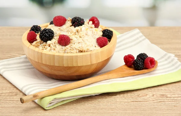 Tasty oatmeal with berries, on wooden table — Stock Photo, Image