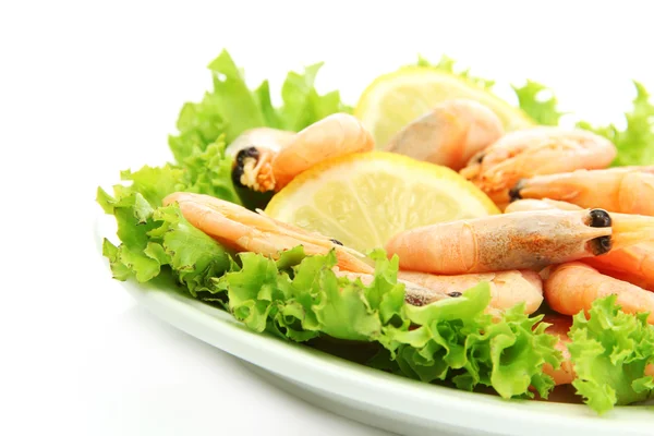 Camarones hervidos con hojas de limón y lechuga en plato, aislados en blanco — Foto de Stock