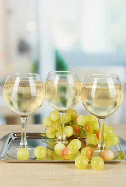 Weißwein im Glas auf Salver auf Zimmerhintergrund — Stockfoto