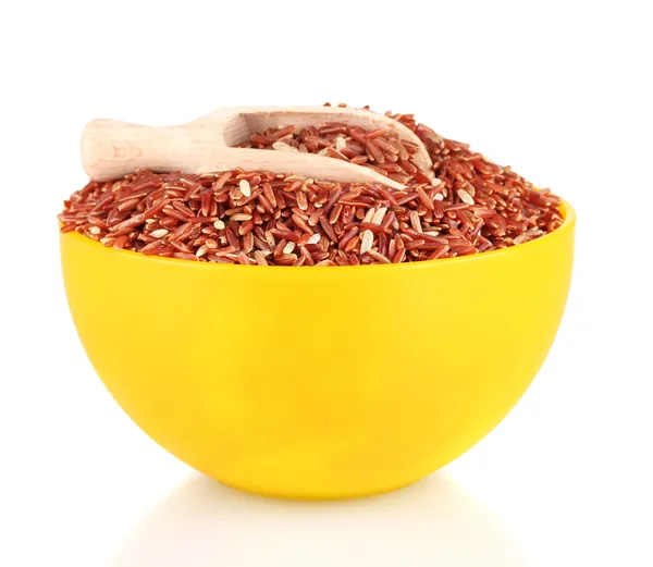 Tahta kepçeli sarı bir tabakta kırmızı pirinç, beyaz üzerine izole edilmiş. — Stok fotoğraf