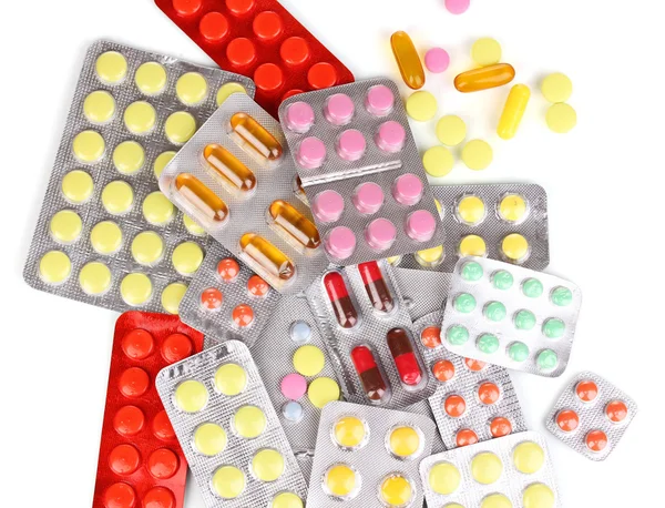 Капсулы и таблетки упакованы в волдыри изолированы на белом крупным планом — стоковое фото