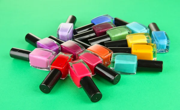 Groep van heldere nagel poetsmiddelen, op groene achtergrond — Stockfoto