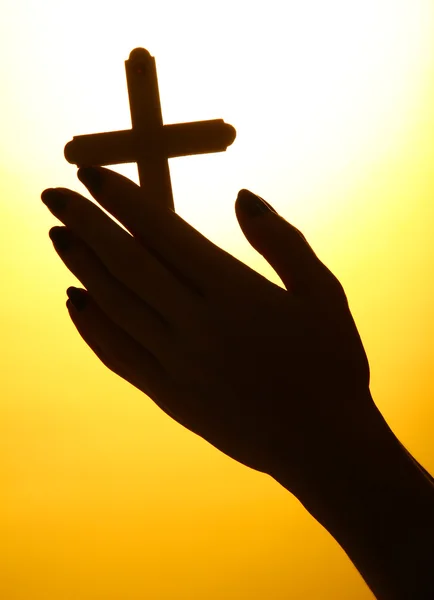 Γυναικεία χέρια με σταυρό, σε κίτρινο φόντο — Φωτογραφία Αρχείου