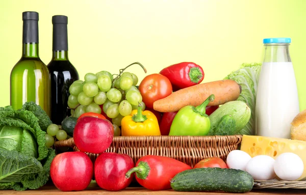 Composición con verduras en canasta de mimbre sobre fondo verde — Foto de Stock